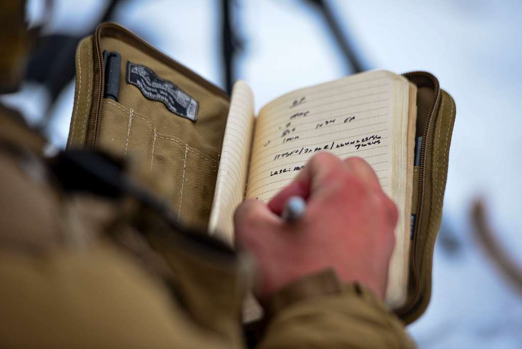 Soldado escribiendo en libreta militar
