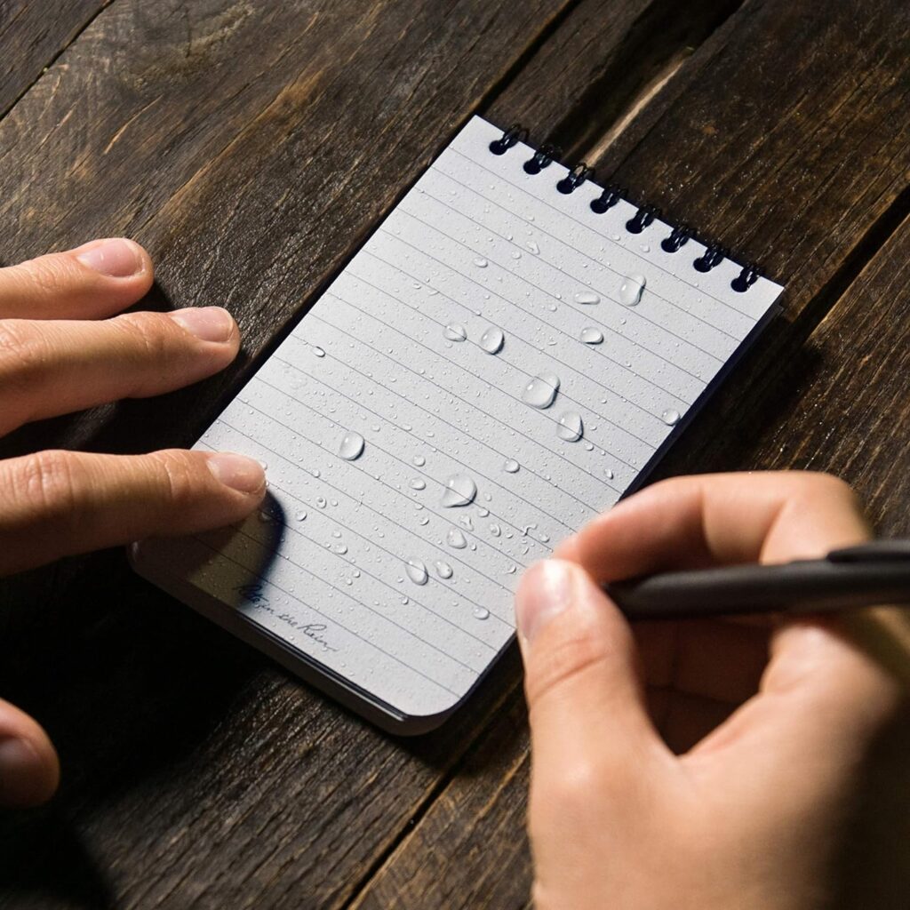 Persona escribiendo en libreta a prueba de agua rite in the rain